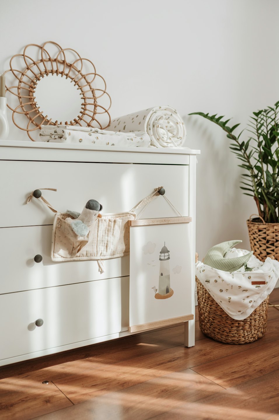 Nursery dresser decorated with baby items and soft textiles.